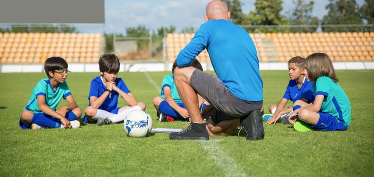 Youth soccer coach with players on the field